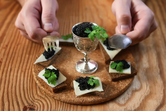 snack black caviar on a wooden background