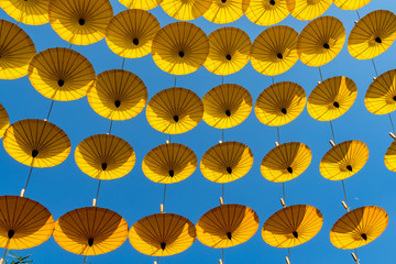 Fototapeta na wymiar Yellow umbrellas on blue sky