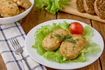 Chicken cutlets with vegetables on a wooden background