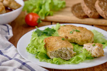 Chicken cutlets with vegetables on a wooden background