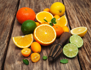 Fototapeta na wymiar Fresh citrus fruits and old juicer