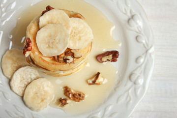 Pancakes with bananas, nuts in the plate.Top view.