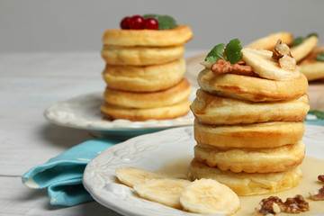 Stack of pancakes with bananas and nuts in the plate.