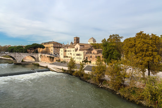 Rome. Italy. View from the right bank of the Tiber: the Pons Cestius (44 BC), the Basilica of St. Bartholomew (998) on the Tiberina island