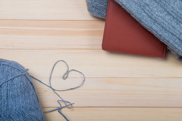 Quiet employment for women in the winter evening. LOVE hobby.  Valentine's Day. Colorful knitted hearts. wooden background, gray woolen thread in the shape of a heart.
