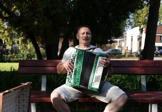 Street musician with harmonica in park