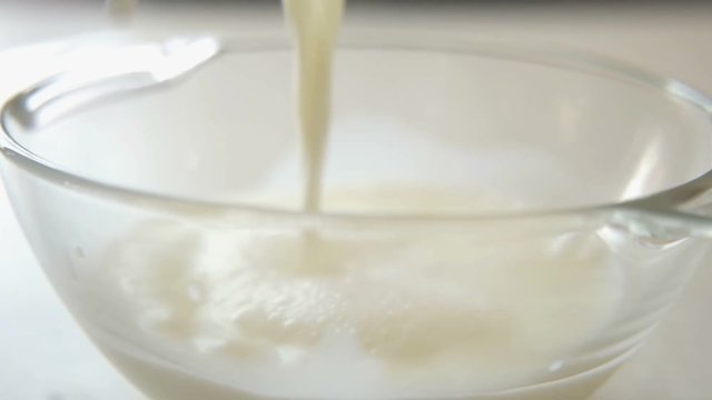 pouring milk in a bowl, close-up, slow motion 