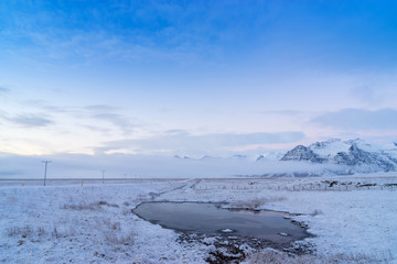 Scenic snow covered land and mountains in Iceland during winter.