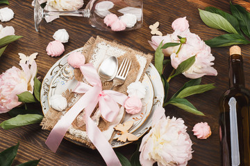 Tableware and silverware with puffy light pink peonies