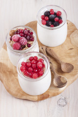 Homemade yogurt with berries in three banks