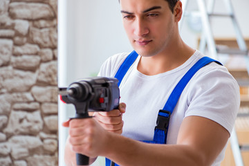 Repairman working with drilling drill perforator
