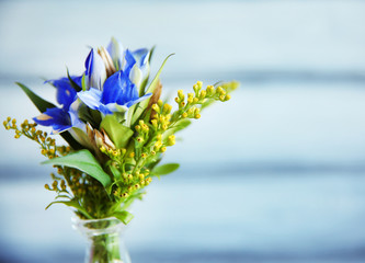 Glass vase with bouquet of beautiful flowers on color background