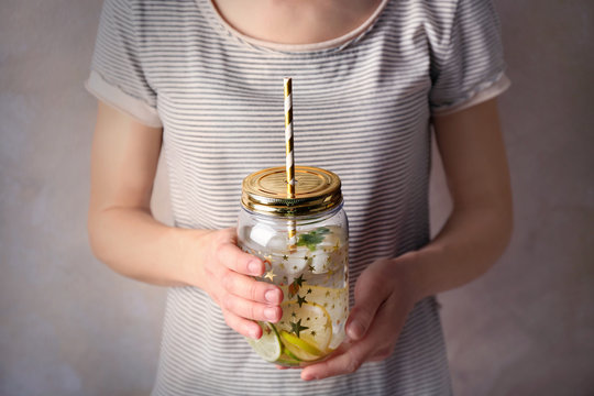 Woman holding lemonade in mason jar, closeup