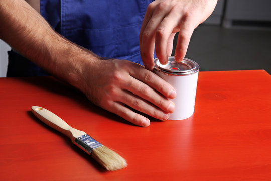 Hands Of Decorator Opening Can With Paint, Closeup