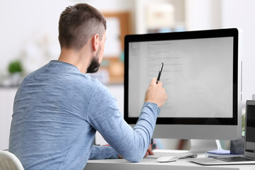 Handsome young programmer working in office