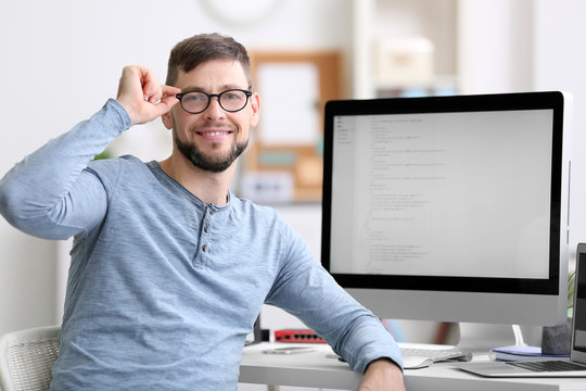 Handsome young programmer working in office
