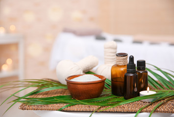 Massage setting with natural oil and herbal compress balls on wicker mat