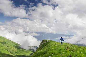 Woman hiking through the high alpine meadows near the top of Mountain