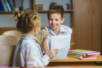 Children learning and doing homework in school classroom