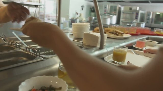 cook puts pieсe of meat on plate with mashed potato and give it to person puts plate on tray