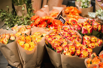 Flowers are near a flower shop on a city street.