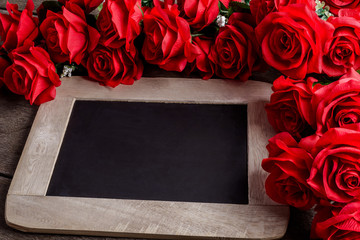 Valentines day greeting card. Red rose flowers and chalkboard on