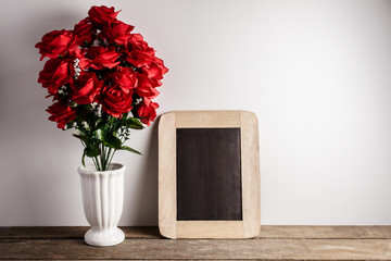 Valentines day greeting card. Red rose flowers and chalkboard on