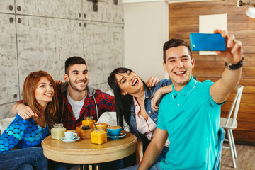 Group of young people having fun in cafe and doing selfie
