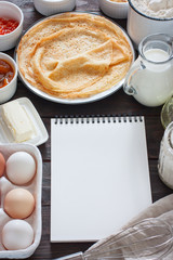 ingredients for making pancakes or cake - flour, egg, butter, milk on the old wooden background. top view. rustic or rural style. background with free text space.