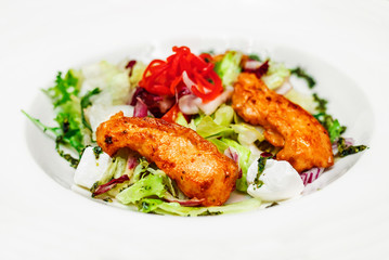 Fresh salad on a plate with fried chicken, feta cheese and herbs