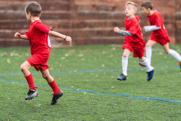 Obraz premium Boys kicking soccer ball at sports field