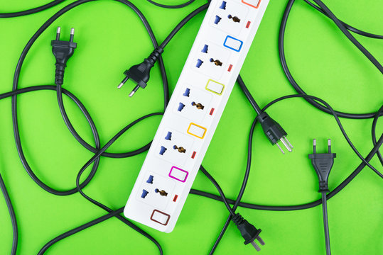 Messy of electrical cords plugs and wires unconnected electrical power strip or extension block  with messy wires, top view on colorful background, messy electric equipment flat lay concept.