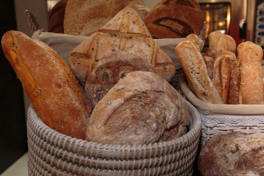 Heap of Bread Rolls Assortment and French Loaf inside Wicker Bas