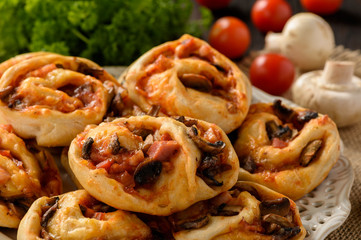 Pizza rolls with tomato sauce, bacon, mushrooms and cheese.