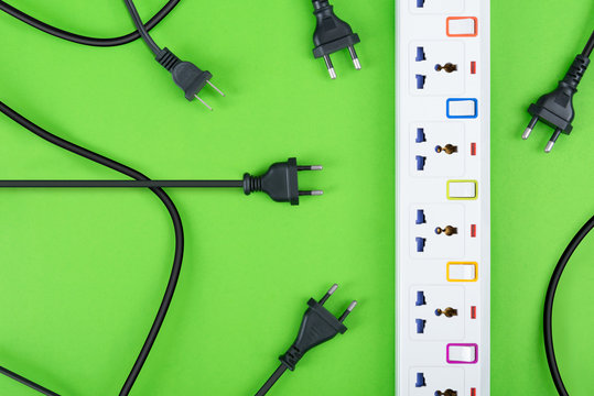 Top view of messy wire unconnected to electrical power strip or extension block on colorful background