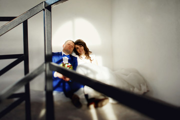 Newlyweds rest on the floor before the window