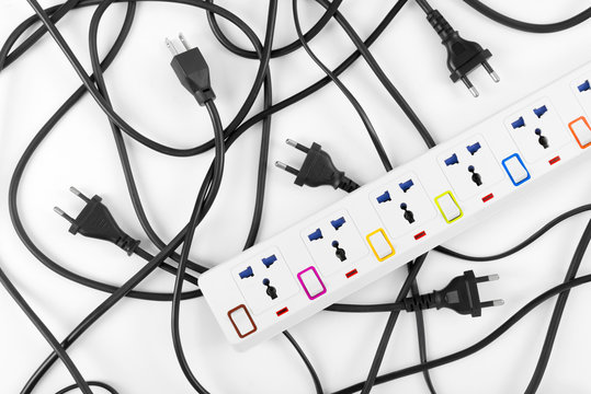 Messy of electrical cords plugs and wires unconnected electrical power strip or extension block  with messy wires, top view on white background, messy electric equipment flat lay concept.