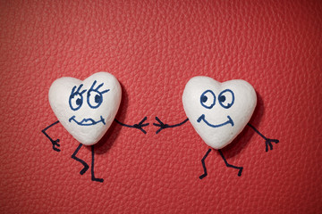 White hearts with happy faces on red leather background