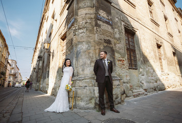 Fototapeta na wymiar Newlyweds are staying on the corner of the building