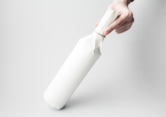 Hand is holding wine bottle on gray background