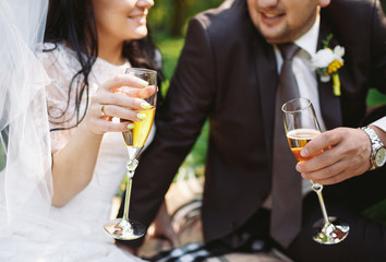 Newlyweds are drinking champagne on the picnic