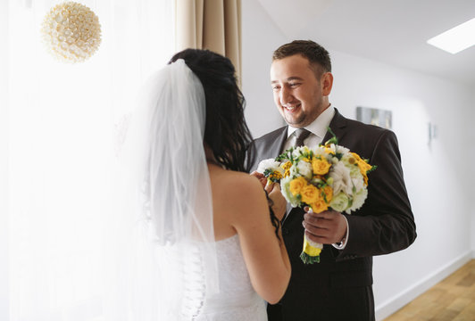 Happy glance of the groom on his bride