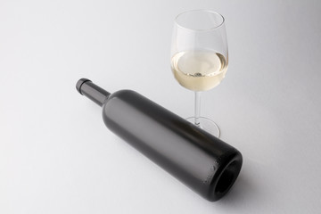 Wine bottle and wine glass on a gray background