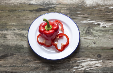 Fresh red pepper cut and placed on a plate on a rustic table,