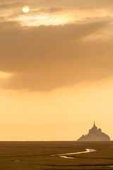 Silhouette of famous Mont Saint Michel on Normandy coast at sunset, France
