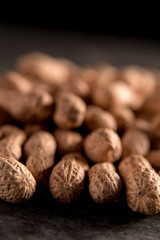 Dried peanut put by a row on dark background