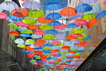 Fototapeta na wymiar Bright colorful umbrellas as street decoration hanging up in the
