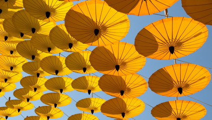 Yellow paper umbrella hanging in the sky