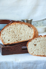 Homemade sourdough bread in a wooden tray on a wooden background
