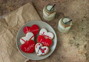 Valentine cookies, milk in a bottle and red hearts